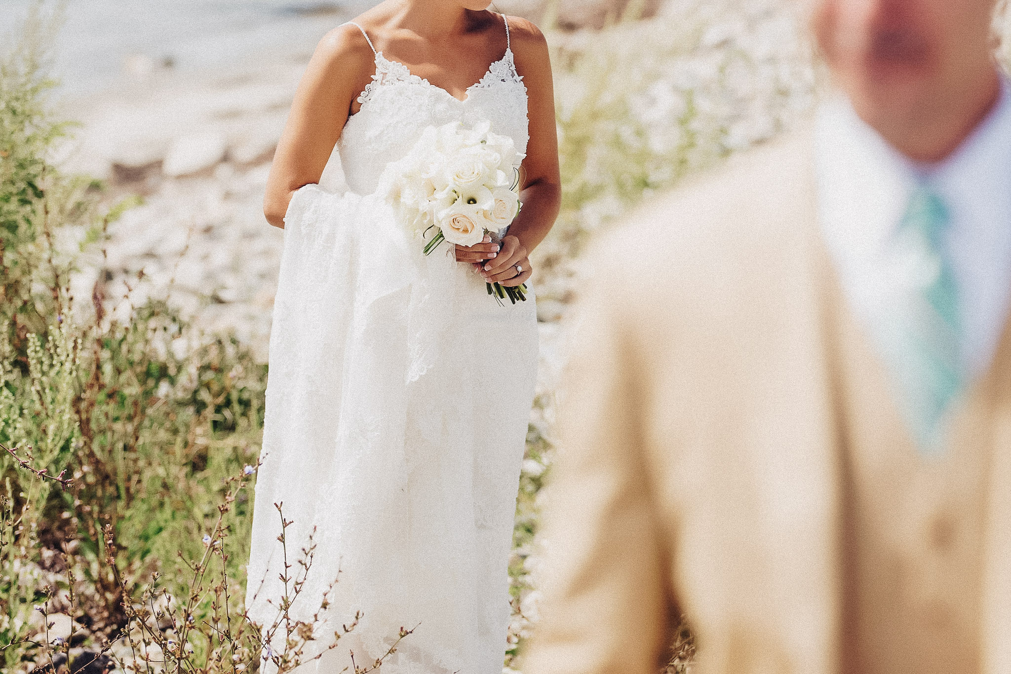 Bride holding her bouquet with the groom softly out of focus